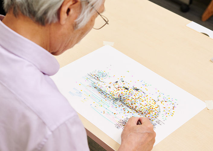 万年筆でカバの絵を描く柴崎春通さん