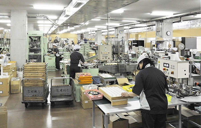 シューケア用品のラベル貼りや梱包が行われる